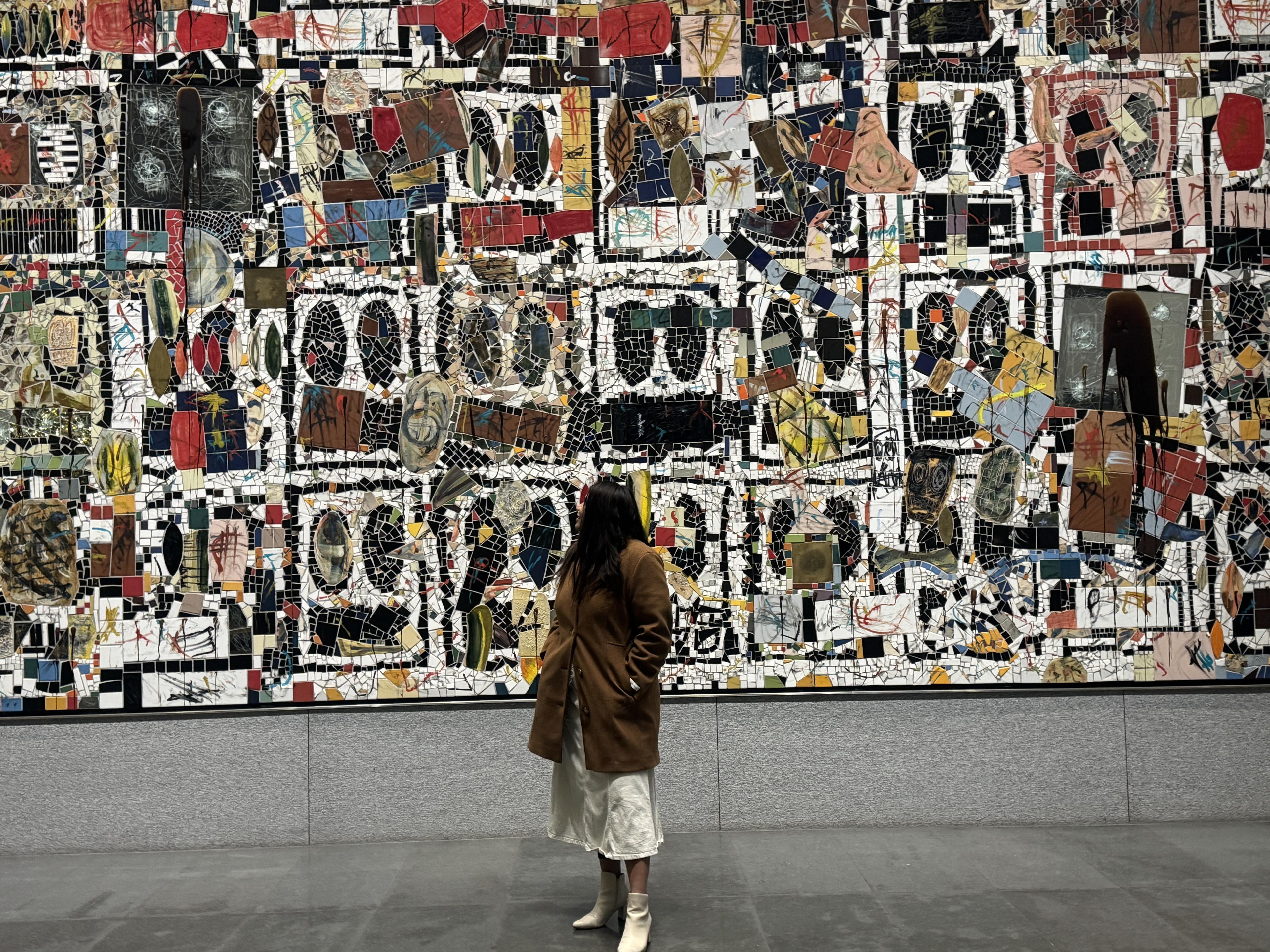 Rashmi Suthar standing in front of her mosaic art installation